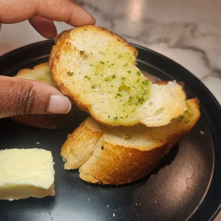 Philly Blogger holding a piece of garlic bread with a nice buttery yellow shine